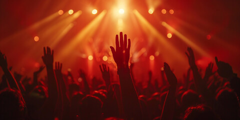 Crowd at a concert with hands raised up in the air.