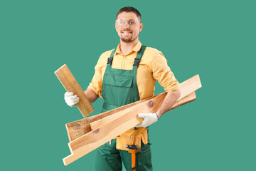 Wall Mural - Male carpenter with wooden planks on green background