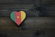 wooden heart with national flag of cameroon on the wooden background.
