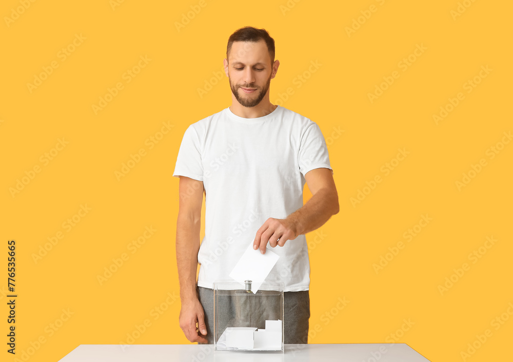 Voting man near ballot box on yellow background