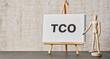 There is notebook with the word TCO. It is an abbreviation for Total Cost of Ownership as eye-catching image.