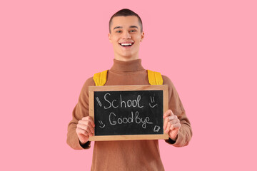 Poster - Cheerful male student holding chalkboard with text SCHOOL GOODBYE on pink background. End of school concept