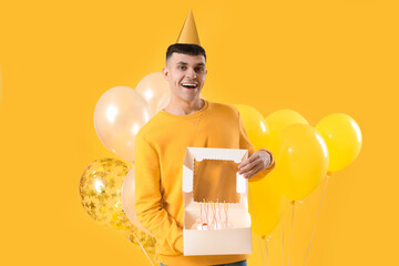 Sticker - Young man with bunch of balloons and birthday cake on yellow background