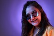 © New Africa - Portrait of beautiful young woman with stylish sunglasses on color background with neon lights