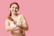 Beautiful young happy woman with bath mitten and massage brush on pink background