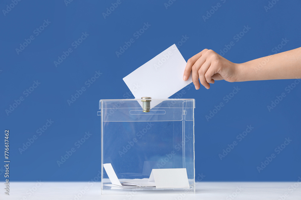 Voting woman near ballot box on table against blue background