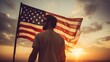 Happy man holding American Flag in the sunset sky freedom and patriotism concept