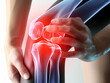 Knie Arthrose, Knochen ist sichtbar. Schmerz strahlt rot aus. Patient hat die Hand draufgelegt.