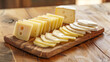 Neatly sliced portions of delicious and diverse cheeses, tastefully arranged on a wooden cutting board in the kitchen