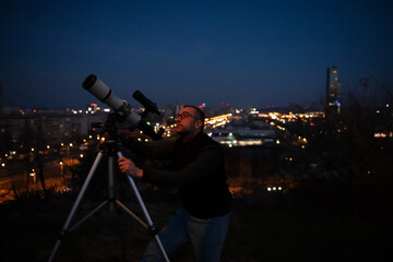 Wall Mural - amateur astronomer looking at the evening skies, observing planets, stars, moon and other celestial 