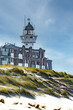 The lighthouse of Egmond aan Zee, Netherlands, behind new buildings and the beach dune in front