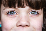 Fototapeta  - Close-up of child's freckled face with expressive eyes