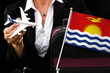 business woman holds toy plane travel bag and flag of Kiribati
