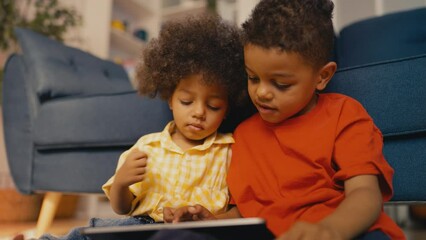 Adorable African American brothers enjoying development game on a tablet