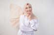 © Reezky - Elegant young Asian Muslim woman wearing white dress with hijab waving in the wind, modelling pose on white background