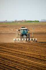 Wall Mural - Farmer operating a tractor for sowing crops on fertile farmland, showcasing modern agriculture