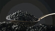 Black Caviar in a spoon on dark background.