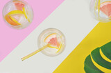 Fototapeta Kwiaty - Drinks, cocktails with fruits on pink and yellow background, summertime. Top view.