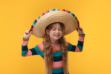 Wall Mural - Cute girl in Mexican sombrero hat on orange background