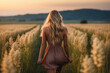 © FutureStock Studio - Beautiful blond woman walking in field view from behind. Back view of blond woman in field. Woman walking in wheat back view.