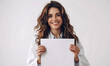 A woman doctor is holding a blank paper sheet in her medical office
