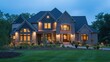 Luxurious suburban house with illuminated windows at twilight, landscaped garden, and clear evening sky.