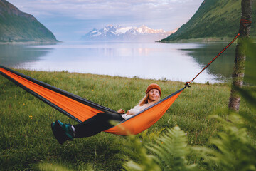 Wall Mural - woman tourist chilling in hammock travel in norway healthy lifestyle summer vacations journey girl r