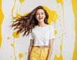 Happy smiling excited young beautiful woman wearing white t-shirt and yellow jeans posing on summer yellow white abstract background