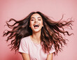 Happy excited young brunette woman on pink background