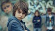 Portrait of a sad little boy standing in front of graffiti wall. School bullying concept