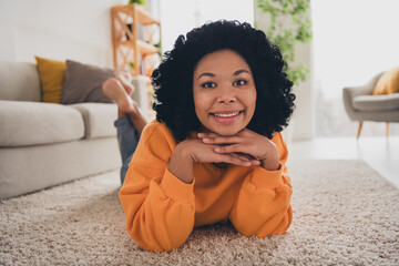 Wall Mural - Photo portrait of lovely young lady lying floor dreamy face relaxed dressed casual orange clothes cozy day light home interior living room