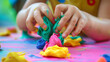 Child hands playing with colorful clay. Homemade plastiline. Plasticine. play dough. Girl molding modeling clay. Homemade clay.