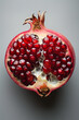 juicy pomegranate fruit with seeds on grey background