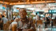 Elderly man sitting alone at a food court table, contemplating while holding a drink, busy background with soft focus.
