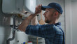 © Oleksiy - Male plumber adjusting boiler in bathroom