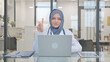 © stockbakers - Doctor in Hijab Shaking Head in Denial while Working on Laptop