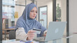 Woman in Hijab Shopping Online on Laptop in Office