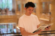 smile Asian young man read book in library