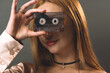 A young woman creatively obscures her eyes with a vintage music cassette tape