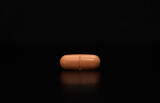Fototapeta  - close up of an isolated pill on black background