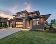 New modern beautiful home exterior at dusk with garage and green grass in front yard stock photo contest winner,