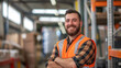 portrait of a smiling worker wearing safety jacket standing in warehouse