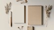 Eco-friendly stationery set mockup made from recycled materials, including a notebook, bamboo pen, and paper clips.