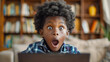 © Anna - Astonished young boy with an expression of surprise while using a laptop at home.