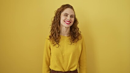 Wall Mural - Laughing young woman exuding confidence and joy, standing proud and happy in yellow isolated background, radiating positive lifestyle traits; cool, lucky and beautiful