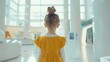 Young girl in a yellow dress exploring a bright modern space