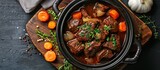 Fototapeta  - A pot filled with German-style braised beef cheeks in a rich red wine sauce, accompanied by tender carrots and onions simmering to perfection.