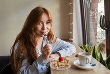 Portrait Of A Red-haired Woman In A Cafe