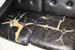 © Colour Laboratory/Stocksy - Broken leather sofa with cracks and holes with hard direct flashlight