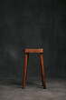 © Joel Forsman/Stocksy - rustic school bench chair in front a blank studio background